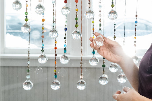 Suncatchers made with colorful beads hanging in a window.